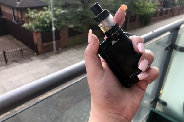 Adult holding a vaping device outdoors — V2 Cigs alternatives