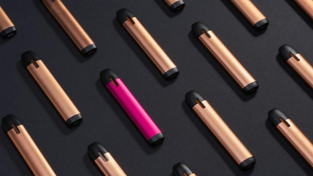 Rows of slim disposable vape pens with one pink device