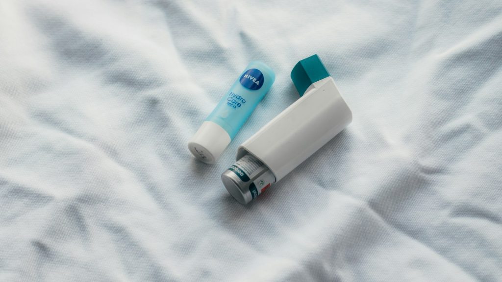Two handheld inhalers lying on a white sheet