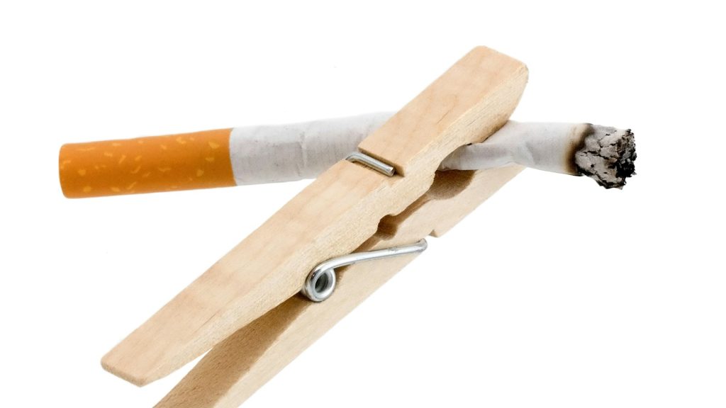 A wooden holder gripping a cigarette